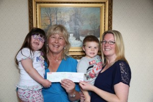 Lucia Butler (from Clongeen) PRO for the London Wexford Association presented cheques to the mum, Deborah O'Farrell, with her two children, Ciara, and her brother, Cian.