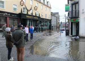 Bystanders look on in amazement as flood water flows out of The Waterfront carpark and down Templeshannon towards the old bridge. Pic: John Walsh