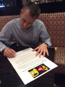 Cycling Ireland President Ciaran McKenna signs the Stayin' Alive at 1.5 petition.