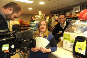 RTE cameraman Neil Denehy recording Erin Dooley and proprietor Michael Hanrahan in Hanrahan's Londis in the Faythe with the news of the lotto winner. Pic: Jim Campbell